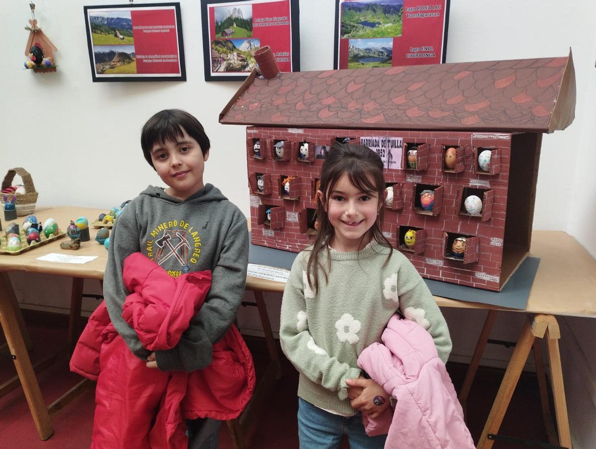 Nel Menéndez, de 9 años, y Clara Pueyo, de siete, junto a la barriada de Tuilla.