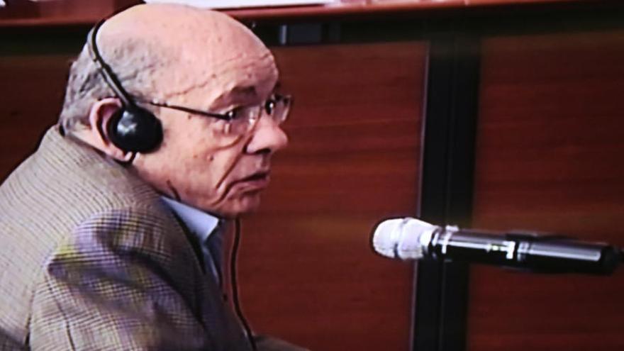 Millet, de perfil, declarant al judici del Cas Palau en una de les pantalles per on es segueix el judici.