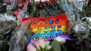 A placard and flowers for the victims of the shooting at a gay nightclub in Orlando are seen in front of the U.S. Embassy in Moscow, Russia, June 13, 2016. REUTERS/Maxim Zmeyev