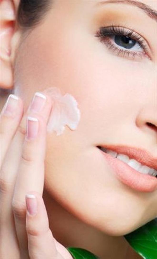 Una consumidora se aplica crema facial.