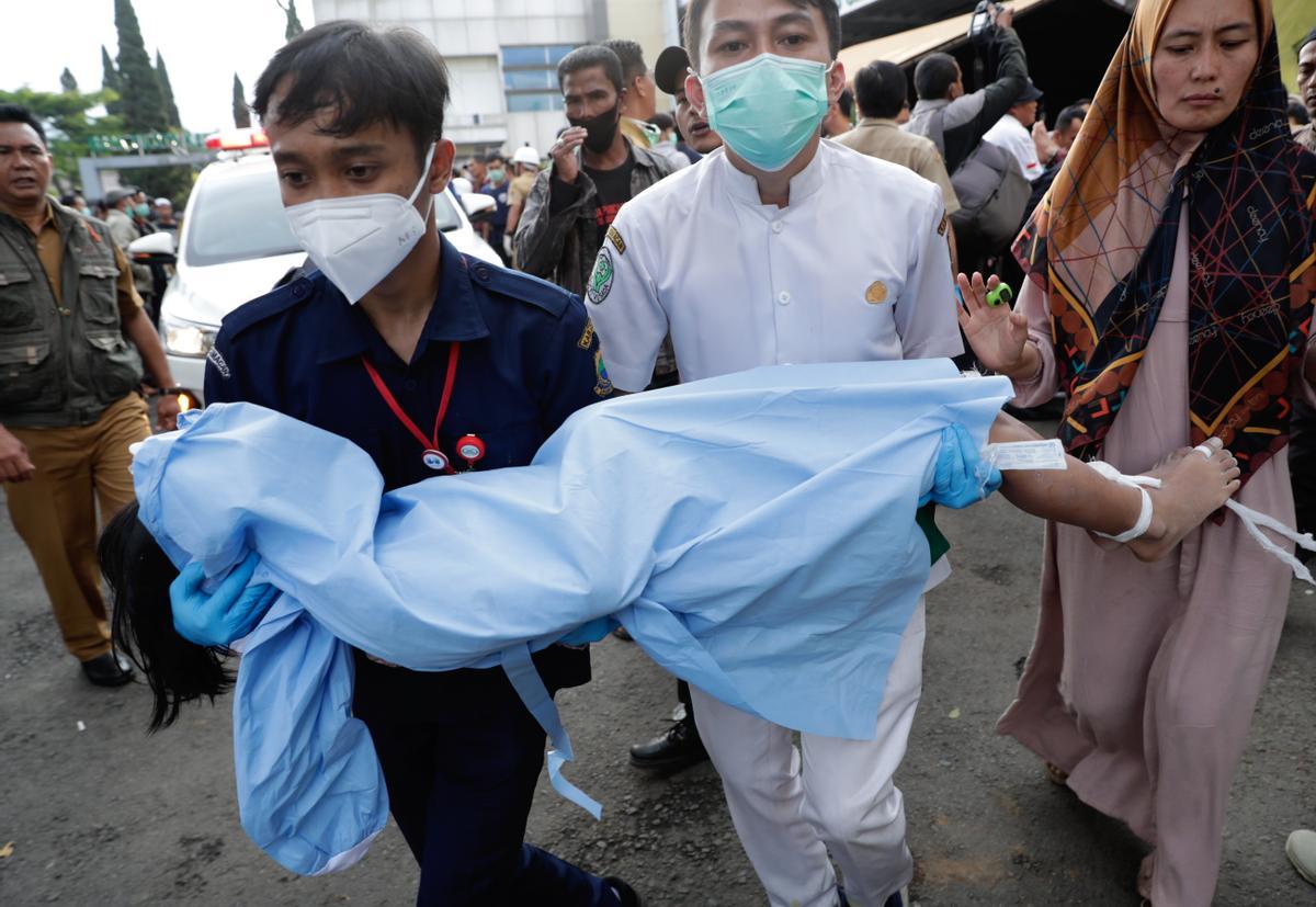Cianjur (Indonesia), 21/11/2022.- Rescuers and a mother carry the body of a boy, victim of the earthquake that hit Cianjur, Indonesia, 21 November 2022. An earthquake with a 5.6 magnitude that hit the southwest of Cianjur District, West Java Province killed at least 20 people and hundreds were injured. (Terremoto/sismo) EFE/EPA/ADI WEDA