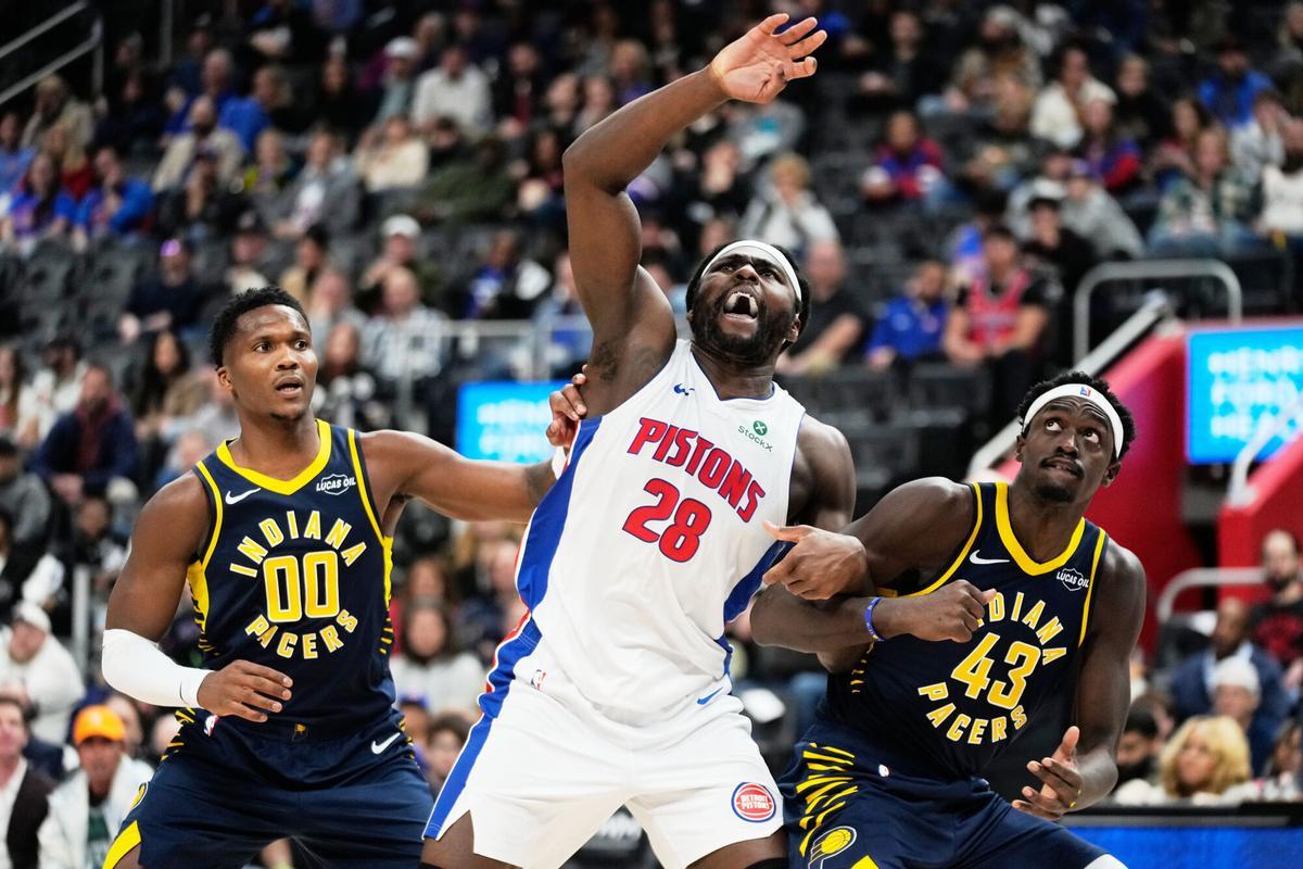Detroit Pistons forward Isaiah Stewart, center, vies for a rebound against Indiana Pacers guard Bennedict Mathurin, left, and forward Pascal Siakam during the first half of an NBA basketball game, Monday, Nov. 17, 2025, in Detroit. (AP Photo/Ryan Sun)