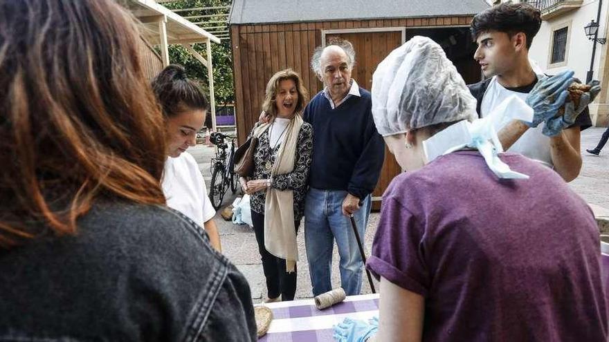 Dos curiosos se acercan a los miembros de &quot;La Folixaria&quot;, ayer, mientras preparan comida vegana para San Mateo.