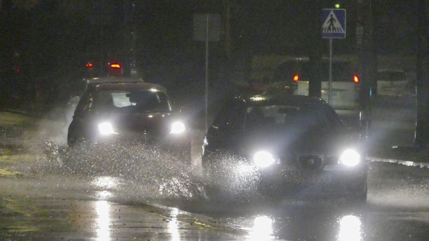 Automóviles circulan con dificultad en la noche de ayer por una carretera urbana en Sevilla capital.