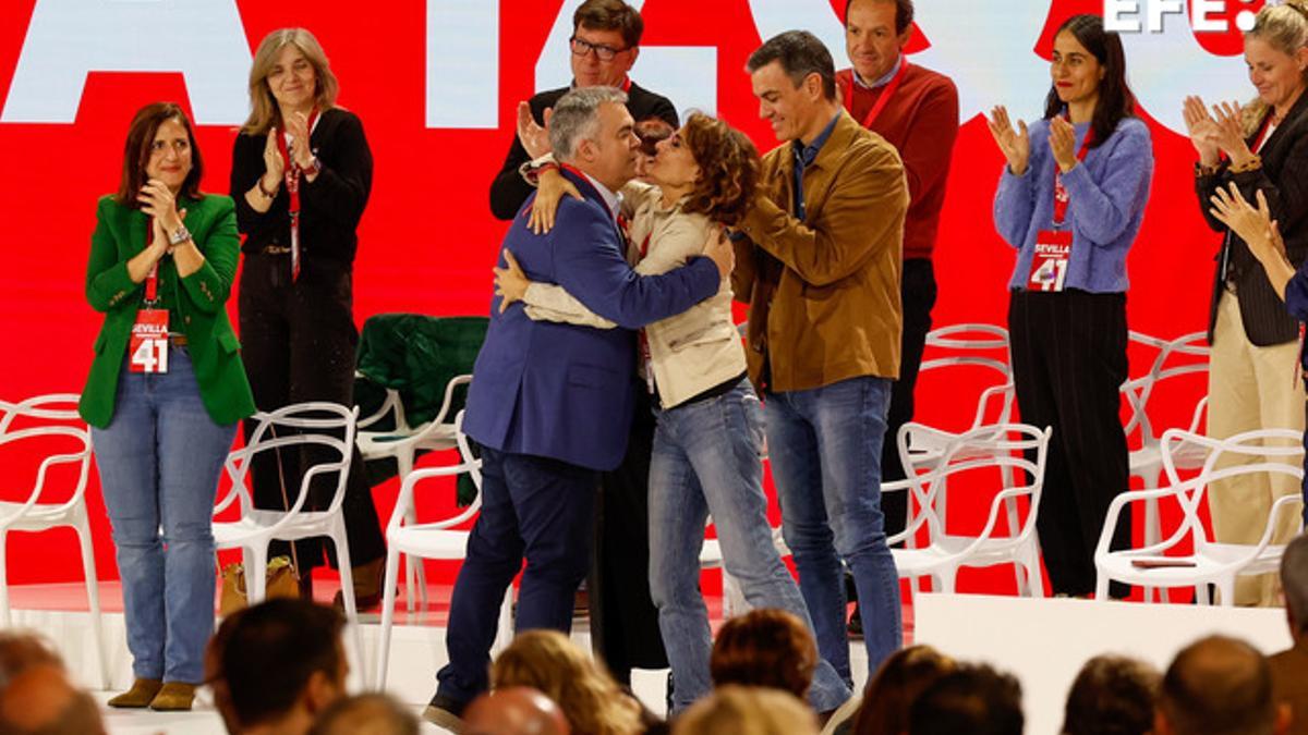El secretario de Organización del PSOE, Santos Cerdán (i) abraza a la vicepresidenta primera y ministra de Hacienda María Jesús Montero (c), en presencia del secretario general del partido y presidente del Gobierno, Pedro Sánchez.