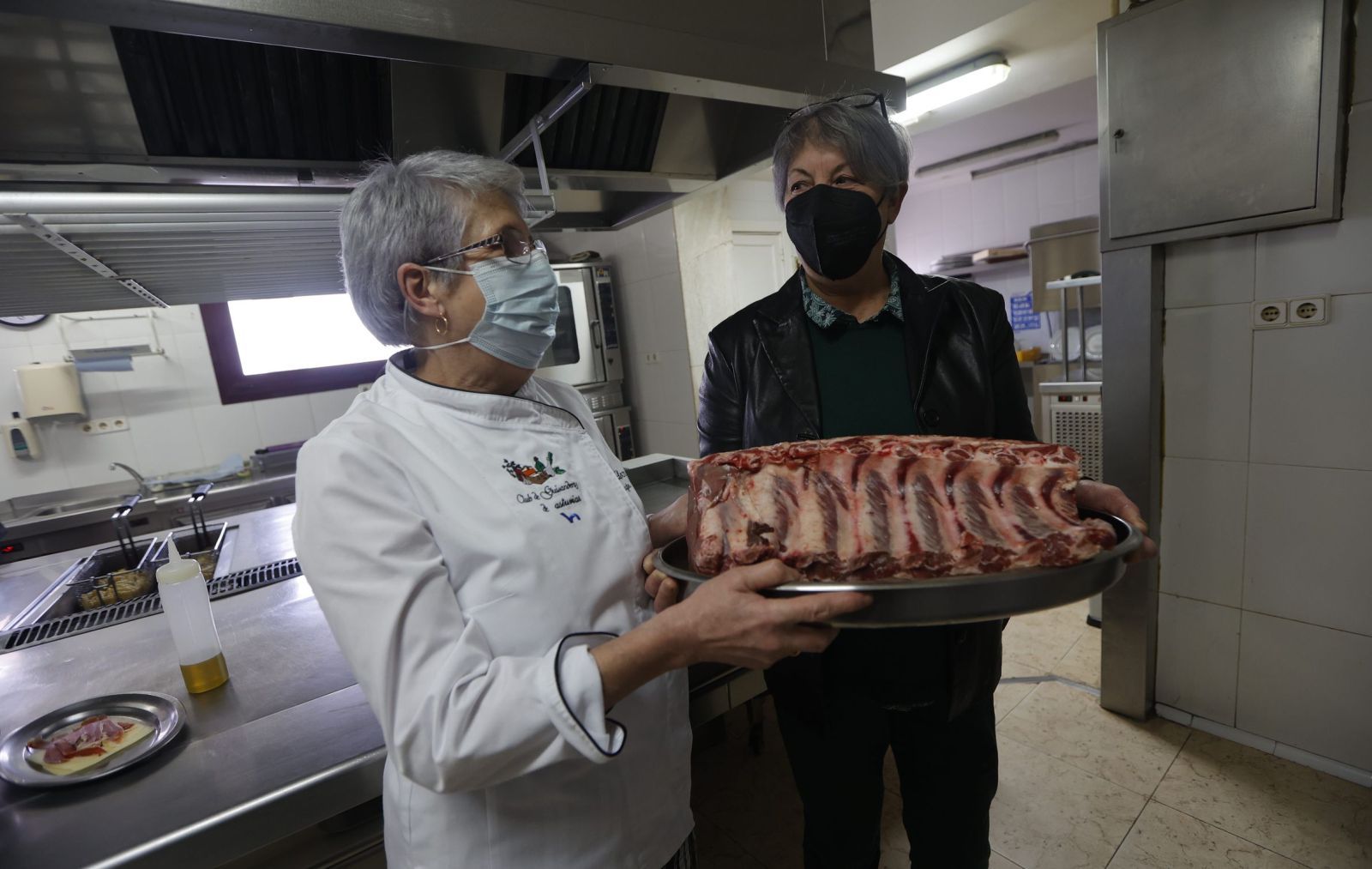 Mayte Álvarez  sostiene el chuletero que le acaba de  entregar Lita  Álvarez, en la cocina de Casa Lula,  en El Crucero.  |   MIKI LÓPEZ