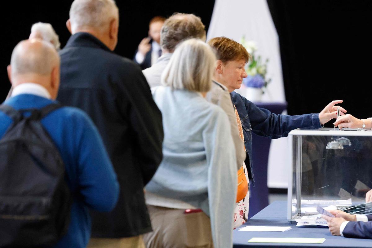 Varios ciudadanos franceses hacen cola para votar en Le Touquet, en el noroeste francés, durante la primera vuelta de las elecciones francesas.