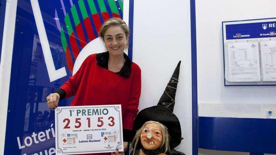 La lotera Marien Fernández con el cartel del número premiado en la administración de Gil de Jaz.