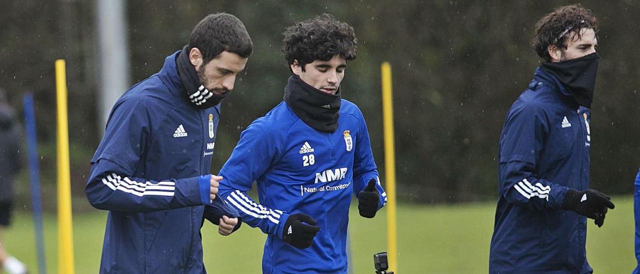 De izquierda a derecha, Aburjania,  Javi Mier y Rodri, ayer, en el entrenamiento del Oviedo. En los círculos, Leschuk, Arribas y Nieto (con el rostro tapado), y Ugarte, ayer, en El Requexón. | |  MIKI LÓPEZ