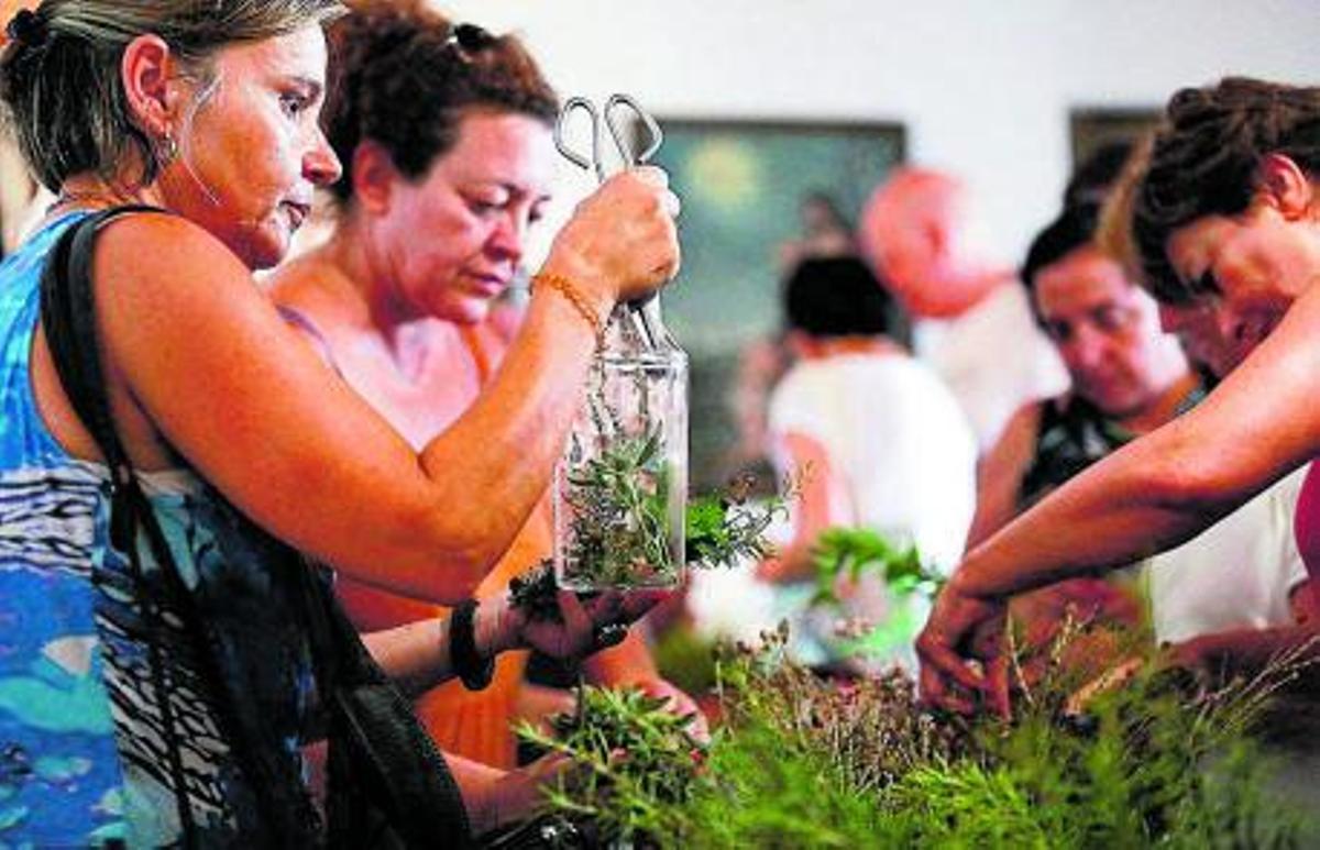 Dos de les alumnes tallen les herbes per preparar les botelles. |