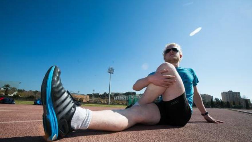 Iván Cano realiza estiramientos durante un entrenamiento en la pista del Tossal.