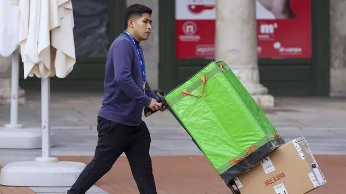 Un repartidor transporta mercancía por la calle.