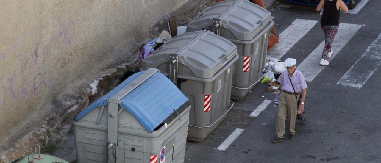 Los peatones se bajan a la calzada en José Reus García, con una acera de 30 centímetros y el paso cortado por basura junto a los contenedores.