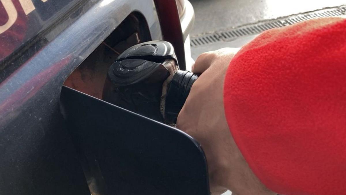 Un trabajador repostando en una estación de servicio.