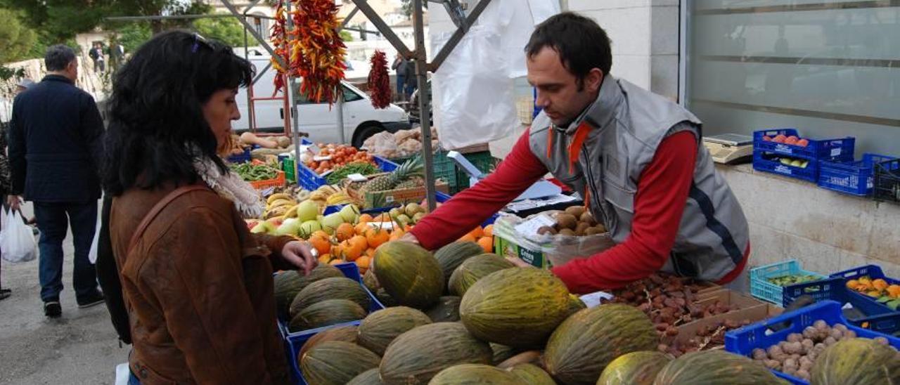 Antoni Estelrich ofrece melones a una clienta.