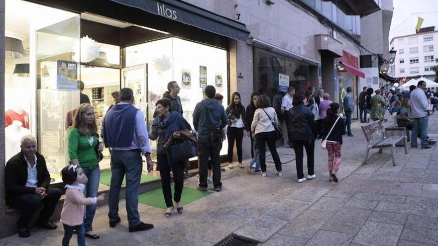 Vecinos en la Praza da Igrexa y (abajo) el photocall de Montoto en su tienda de Colón.