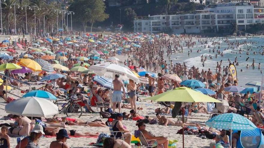 Bañistas disfrutando del sol y el calor a finales de julio en Samil. // J. Lores