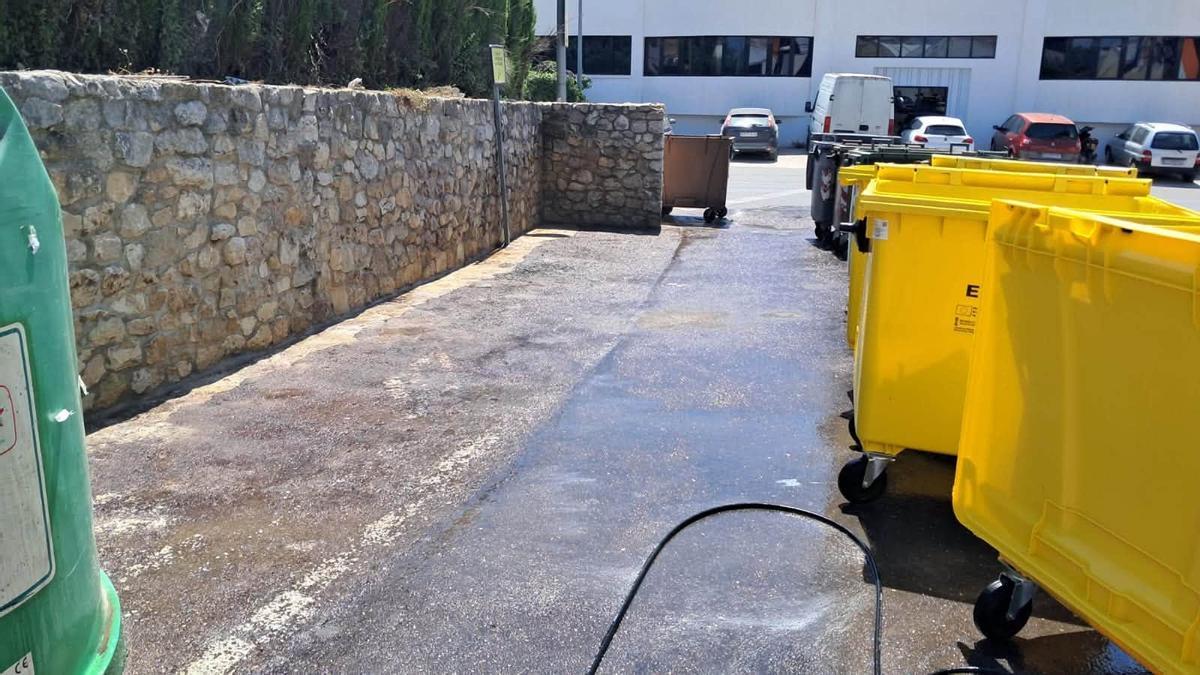 Trabajos de limpieza en un área de contenedores abierta.