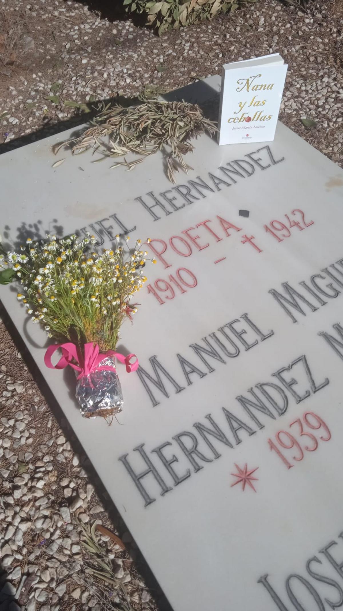 Ramillete de flores de manzanilla y el libro &quot;Nana y las cebollas&quot; que Martín depositó en la sepultura del poeta