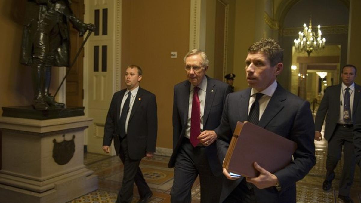 El líder de la mayoría demócrata en el Senado, Harry Reid (segundo por la izquierda) se dirige a su despacho en el Capitolio, tras reunirse con Obama en la Casa Blanca, el viernes.