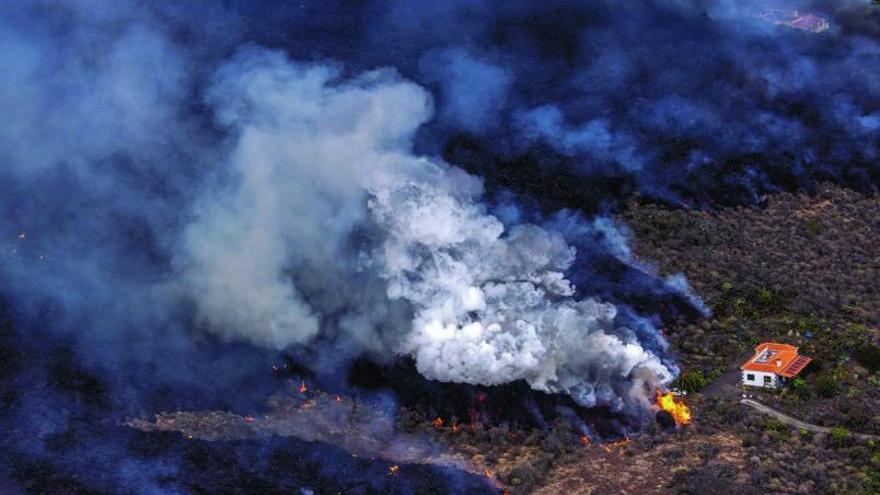 Imagen tomada desde un helicóptero de una casa rodeada de lava en Los Llanos de Aridane, en La Palma.   | // LOVETHEWORLD