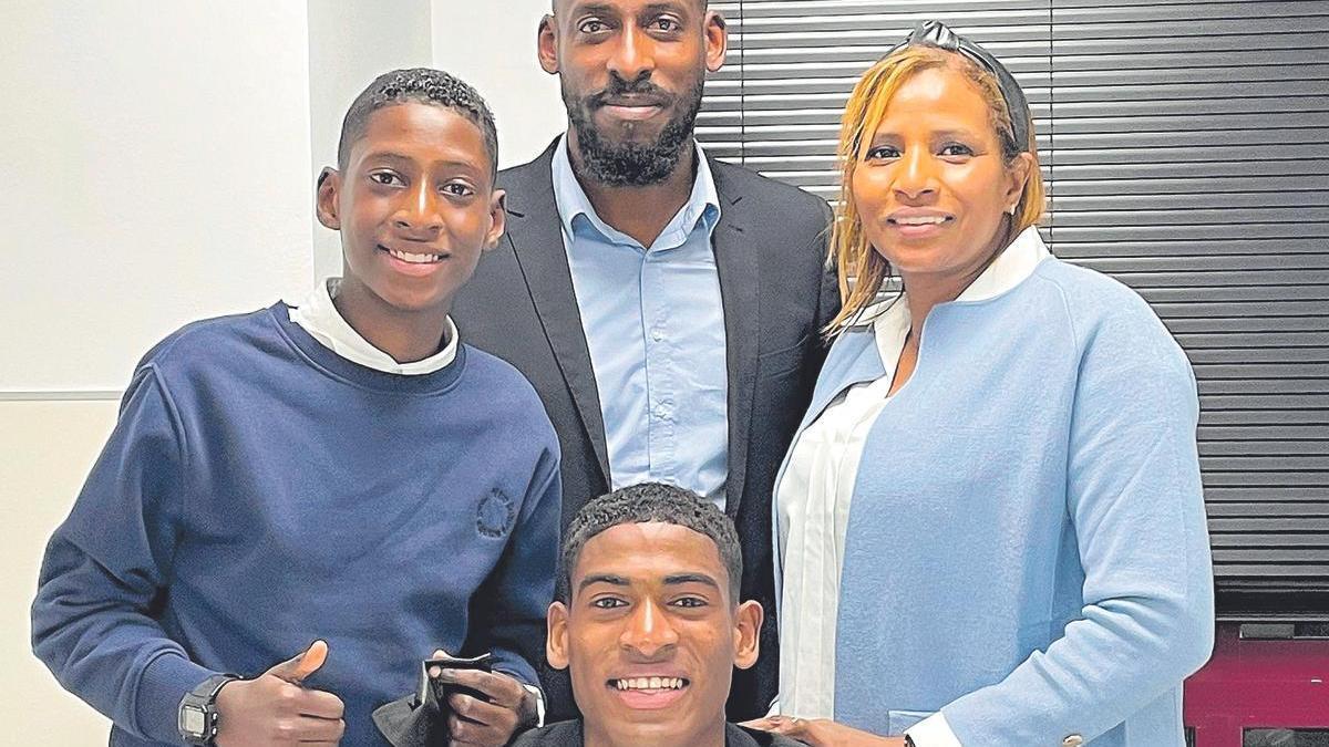 El joven central del Valencia CF Cristhian Mosquera posa en el momento de la firma de su nuevo contrato con su padre Cristofer, su madre Loreidis y su hermano Yulian