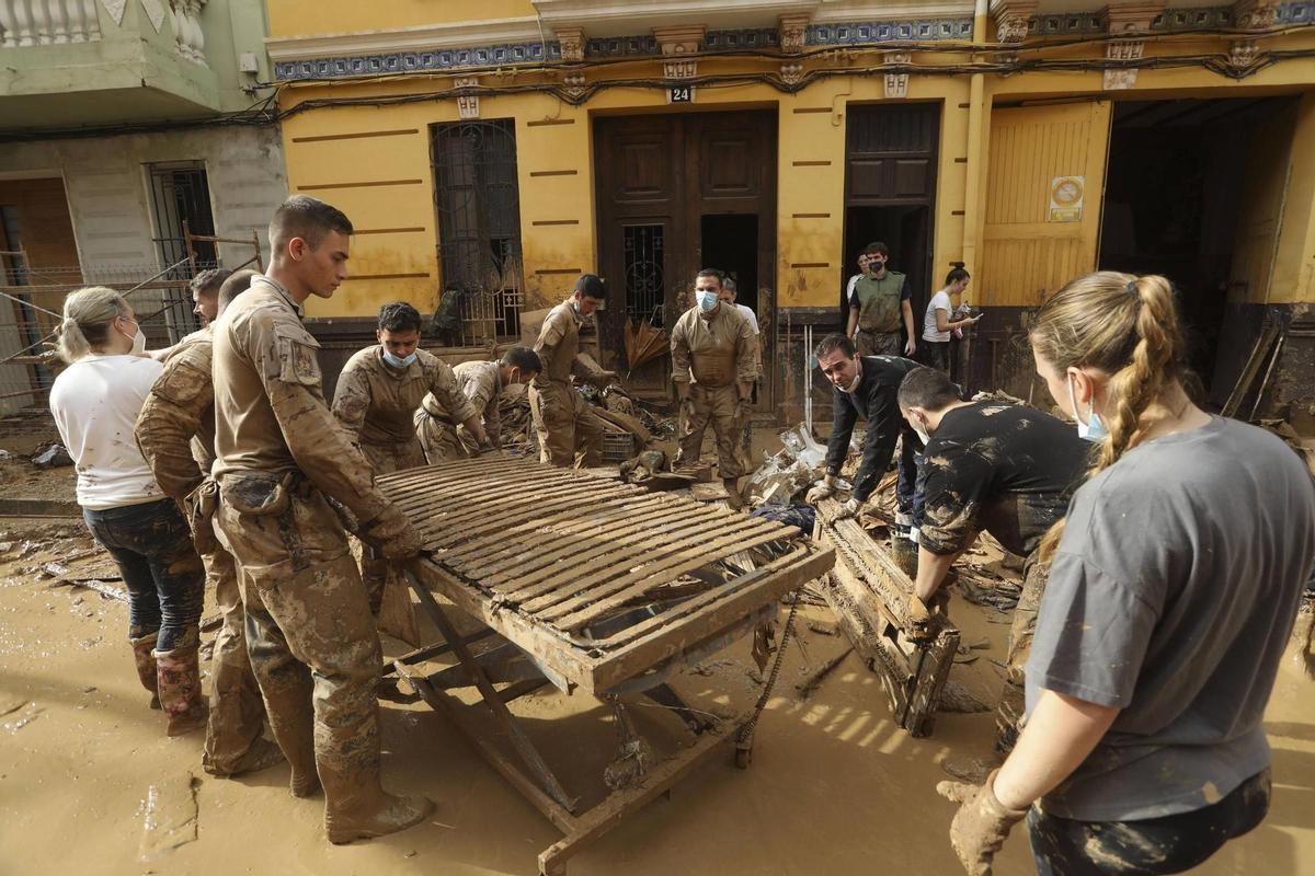 Militares con un gran somier lleno de barro en Albal.