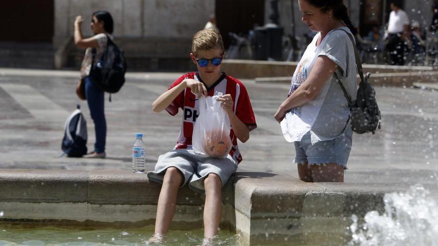 Un niño se refresa en la fuente de la Plaza de la Virgen. Foto: M. A. Montesinos