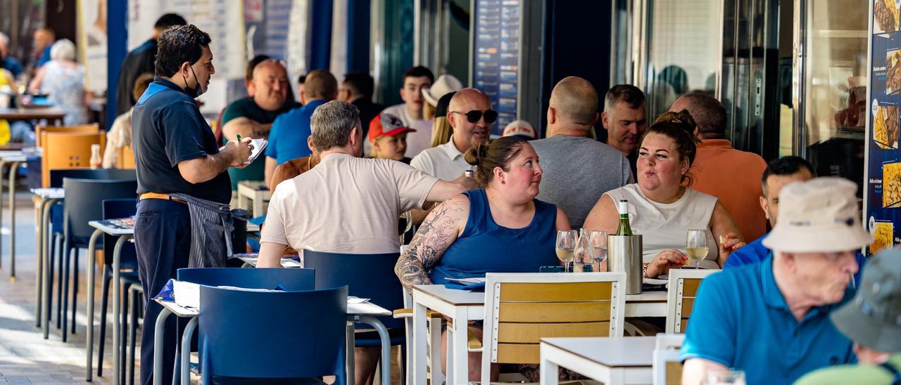 Un camarero atendiendo una terraza de un restaurante en Benidorm.