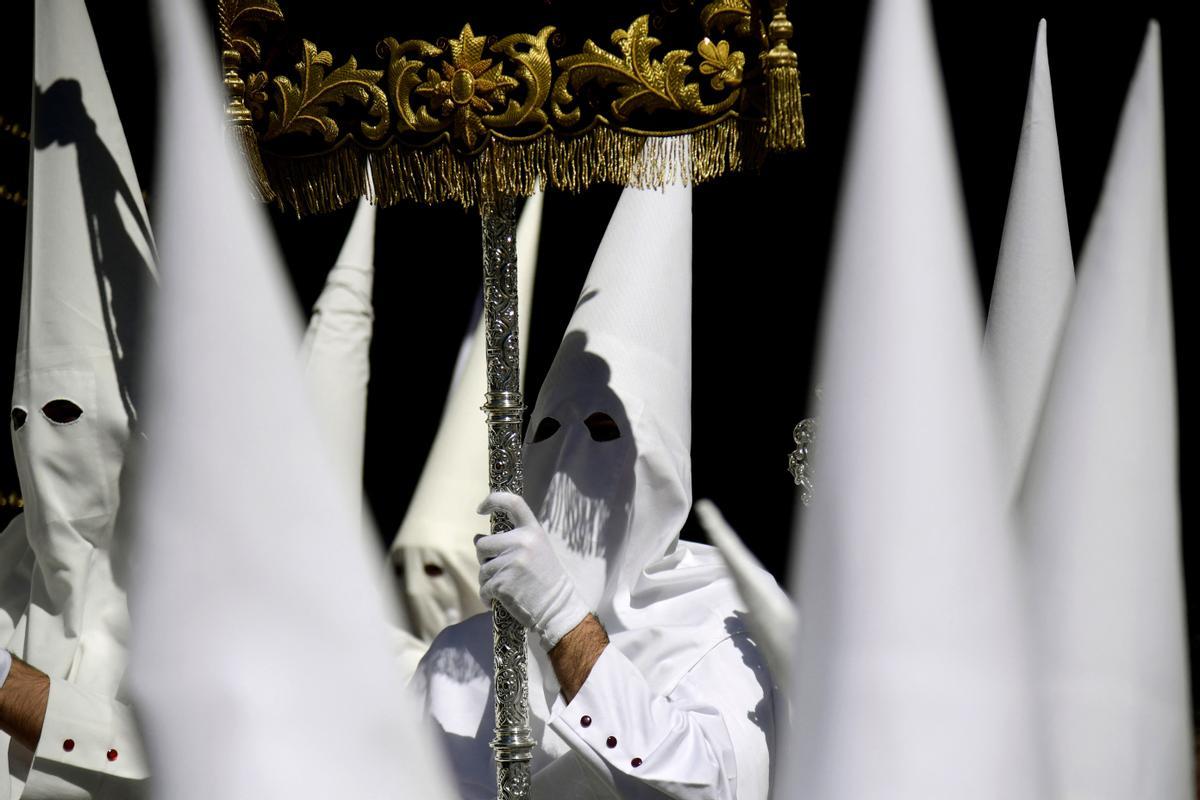 Penitentes de la hermandad de La Paz participan en la procesión del Domingo de Ramos en Sevilla