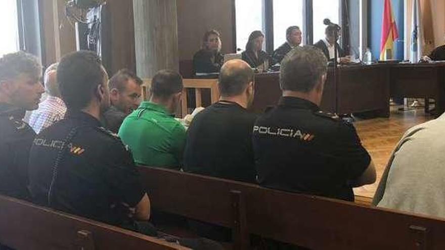 Los acusados, custodiados por policías nacionales, en el juicio que empezó ayer en Vigo. // FdV