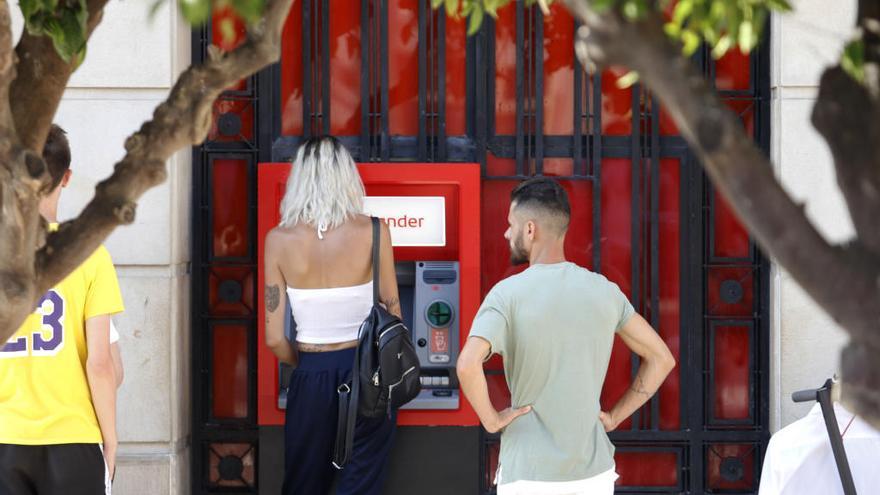 Clientes sacan dinero de un cajero automático en Málaga.