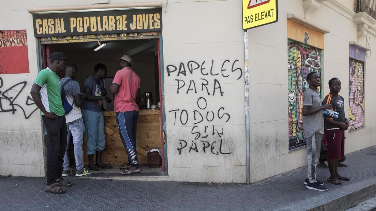 Varios voluntarios se ofrecen ante el Casal de joves de Lleida para dar de comer a los migrantes sin trabajo.