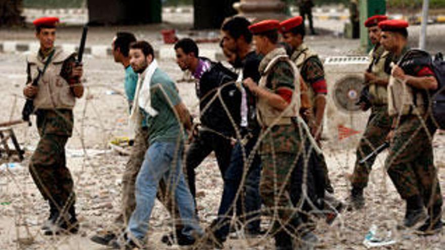 Soldados egipcios custodian a un grupo de detenidos en la plaza de la Liberación de El Cairo.