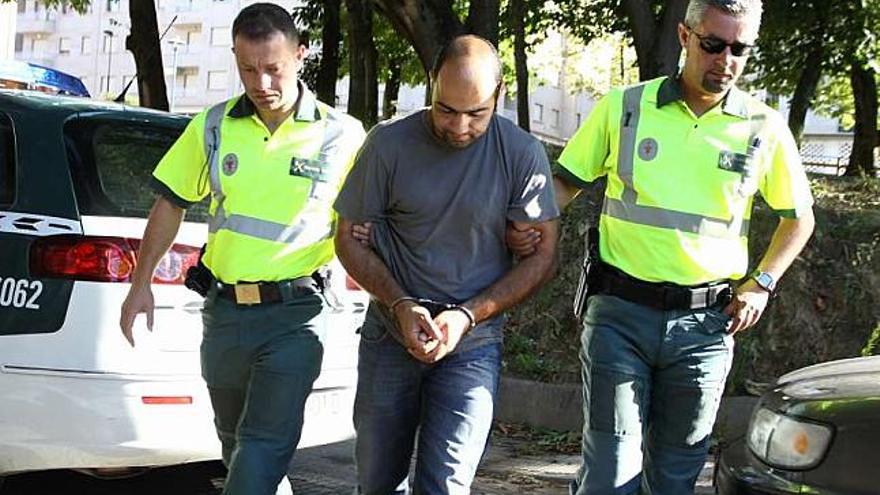 El camionero luso, a su llegada a los juzgados de Cangas, custodiado por la Guardia Civil. / c. giménez