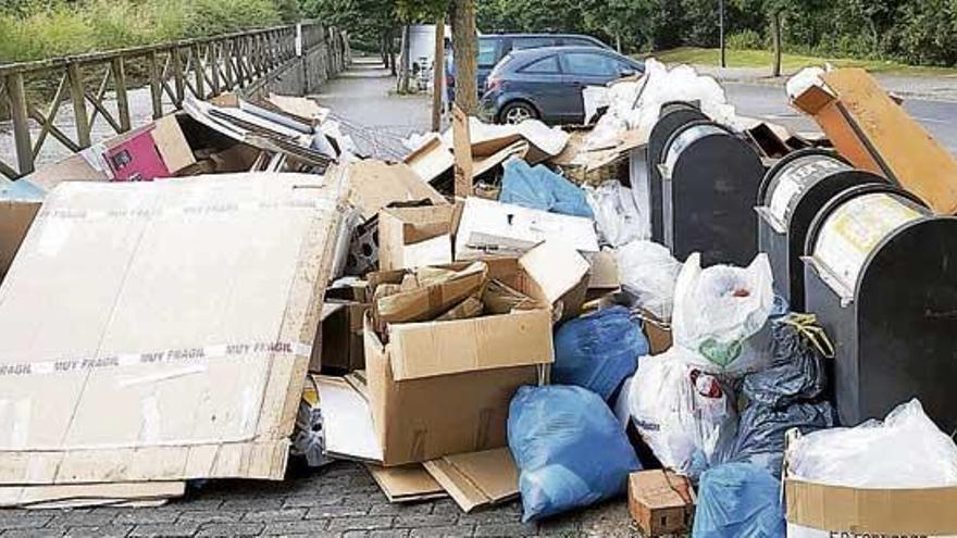 Basura rodeando contenedores y bloqueando la acera, ayer por la mañana en Gutiérrez Mellado. la opinión