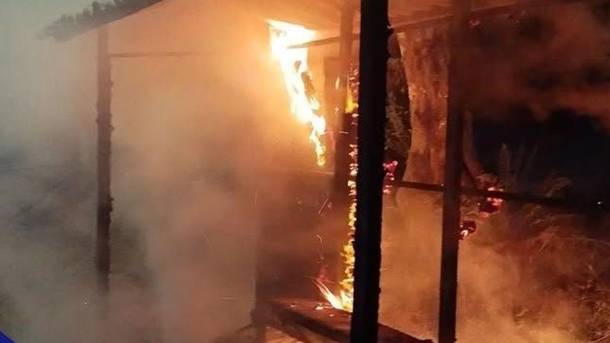 La marquesina de autobús en llamas al propagarse el fuego de un contenedor.