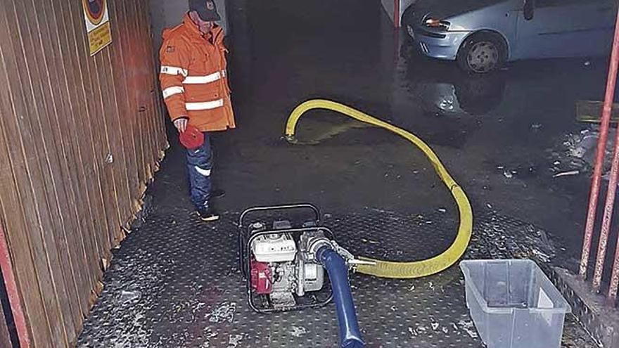 Uno de los integrantes del grupo de voluntarios observa cÃ³mo el agua afectÃ³ a un garaje.