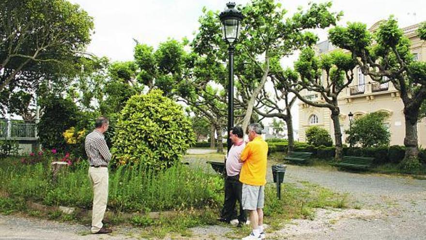 Por la izquierda, Javier García, Ovidio Vila y Pepe Llenderrozes observan la maleza del parque de Castropol.