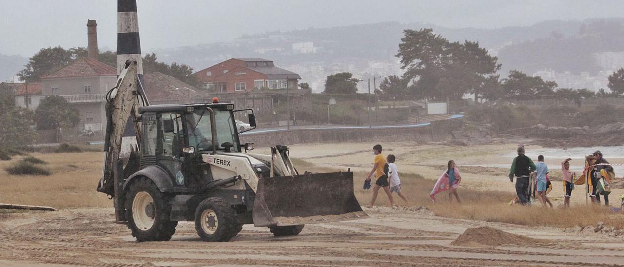 Una máquina excavadora avanza en la explanación del arenal ante el éxodo de usuarios.   | // SANTOS ÁLVAREZ