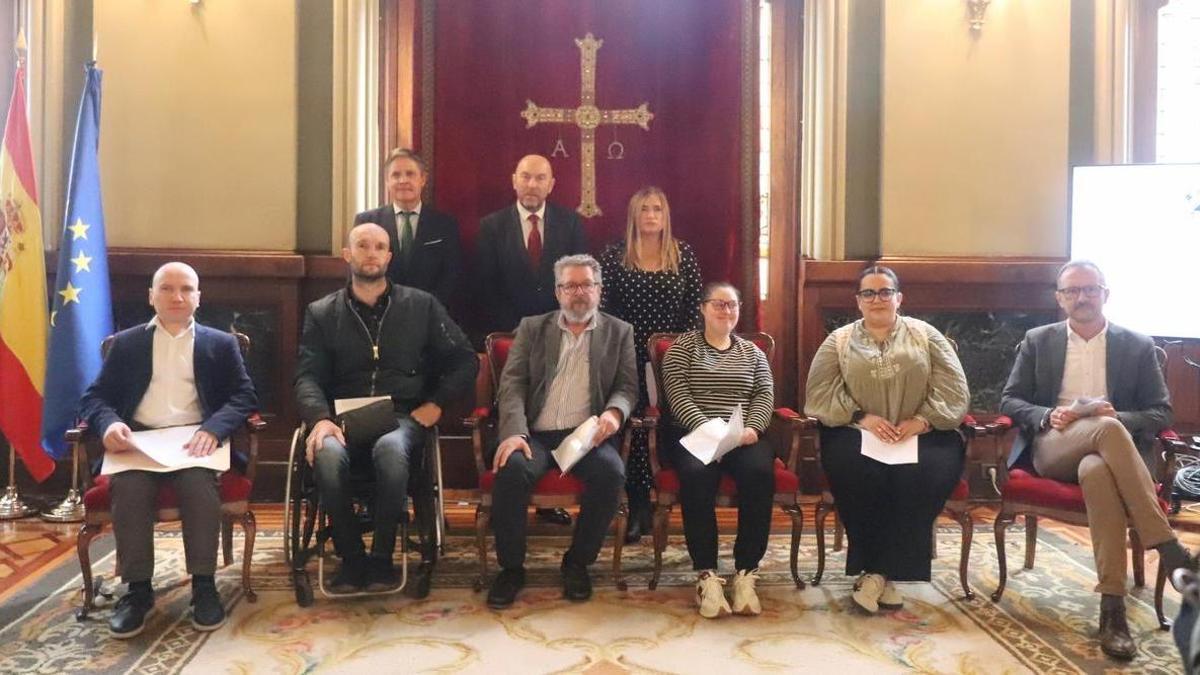Detrás de pie, Nuño, Cofiño y Oviedo, junto a representantes de colectivos de ayuda a personas con discapacidad, en la Junta, en Oviedo, este lunes.