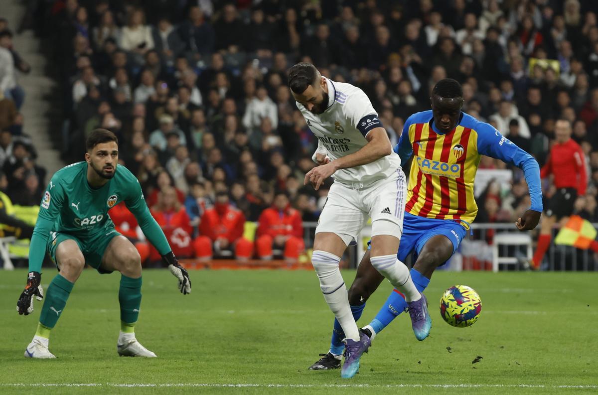 MADRID, 02/02/2023.- El delantero francés del Real Madrid, Karim Benzema (c) intenta superar al portero del Valencia, el georgiano Giorgi Mamardashvili (i) durante el partido de LaLiga que Real Madrid y Valencia disputan este jueves en el Santiago Bernabéu. EFE/ Juanjo Martin