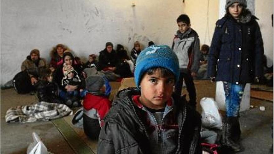 Menors inmigrants esperen amb les seves famílies per inscriure&#039;s en un camp de refugiats de Sèrbia.