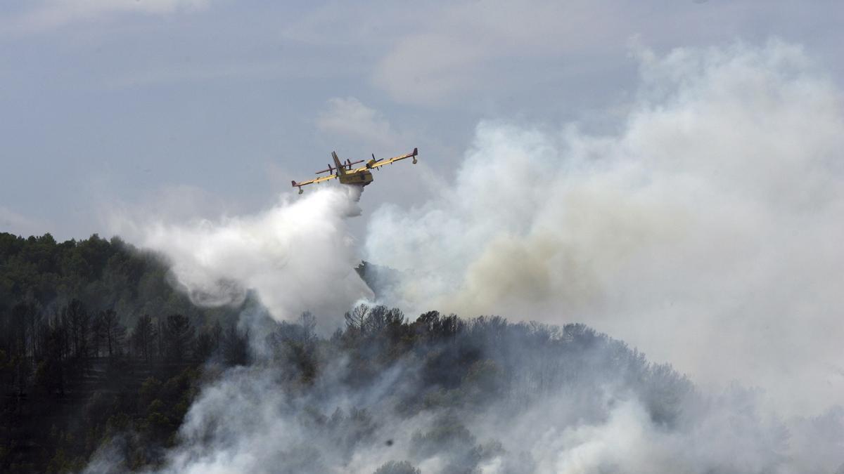 Un hidroavión tira agua sobre un incendio.