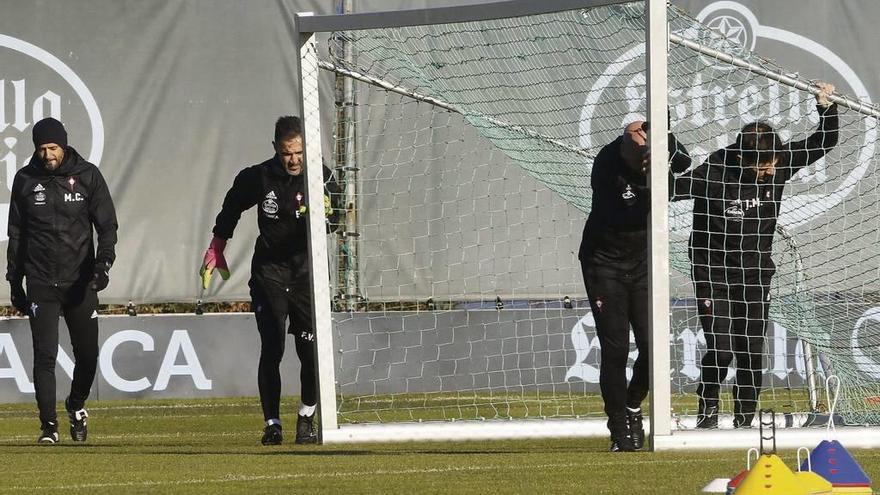 Miguel Cardoso (izquierda) con tres de sus ayudantes, que mueven una portería, ayer, en el entrenamiento en A Madroa. // Alba Villar