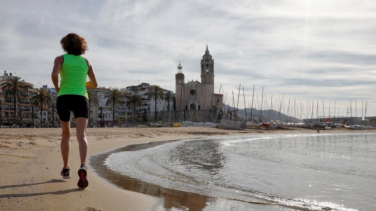 Una mujer hace ejercicio en la playa de Sitges, el 4 de mayo del 2020