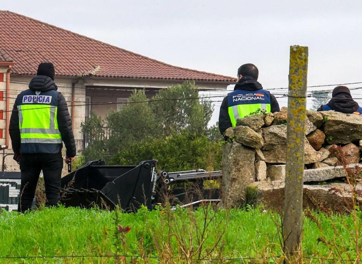 Dos agentes contemplan el
trabajo de las excavadoras. | Iñaki Abella