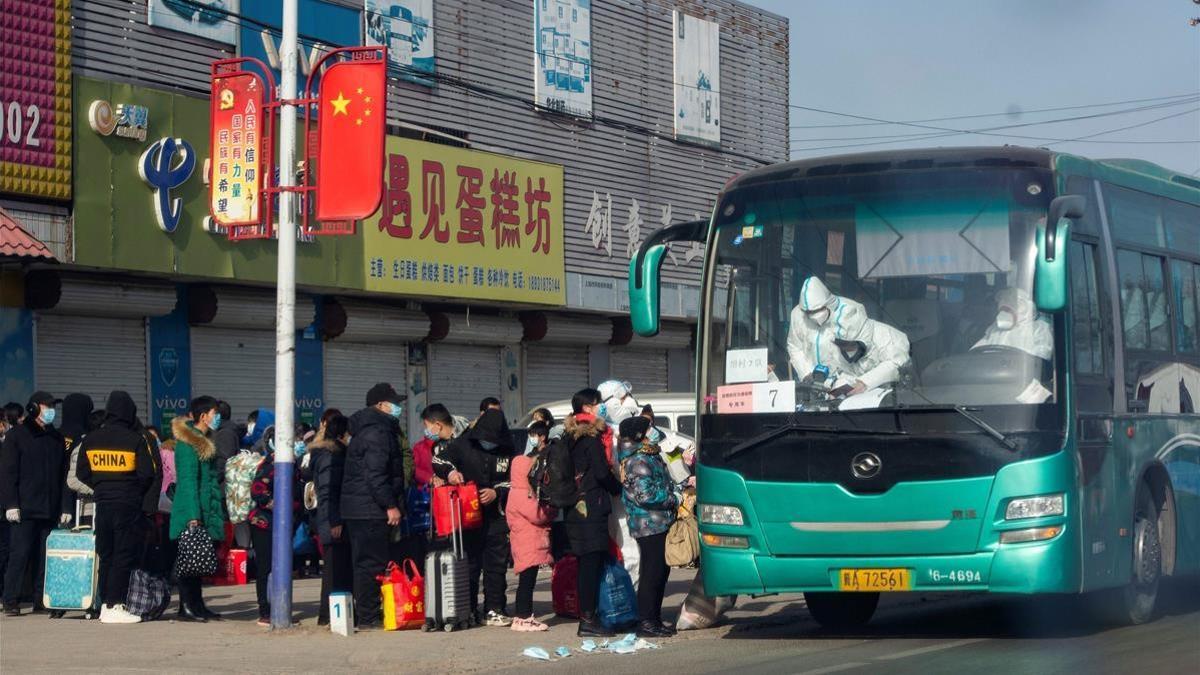 Residents line up to get on a bus at Gaocheng district to be taken to centralized quarantine in Shijiazhuang  in central China s Hebei province on January 11  2021  after the district has been declared high risk and sealed off  and tens of thousands have already been tested for the virus  (Photo by STR   CNS   AFP)   China OUT