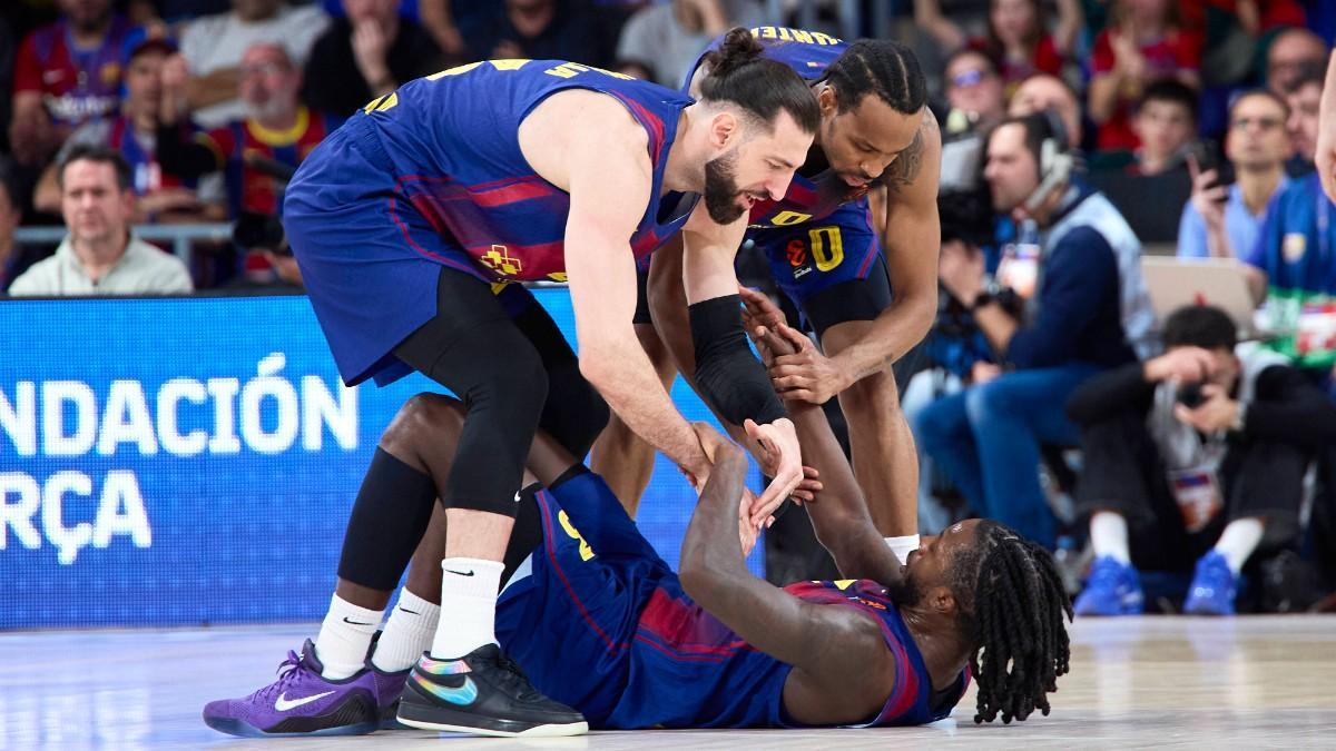 Tornike Shengelia y Kevin Punter ayudan a levantarse del suelo a Myles Cale