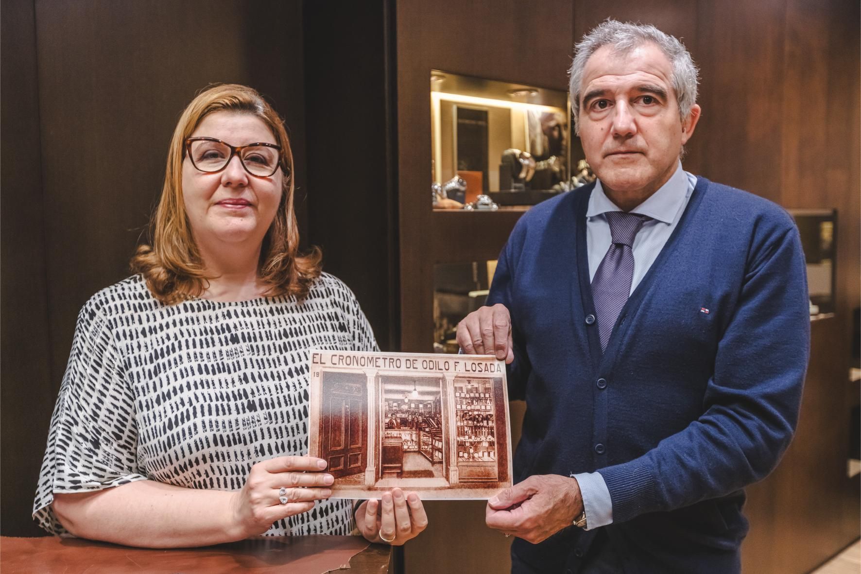 Los hermanos Odilo y María Fernández con la foto del negocio que abrió su abuelo en 1928 en Ourense